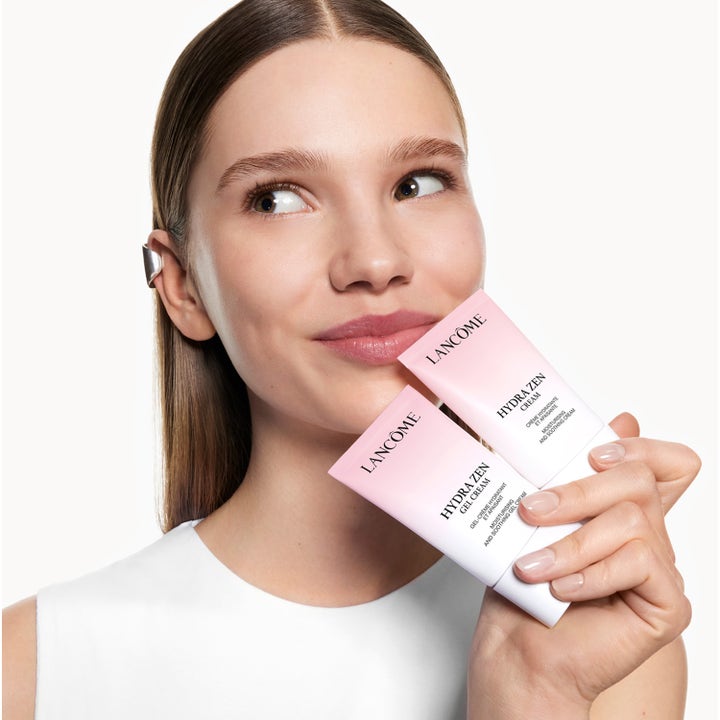 Lancôme Hydra Zen Anti-Stress Day Cream 30 ml rauhoittava päivävoide nainen pitelee vaaleanpunaisia tuubeja