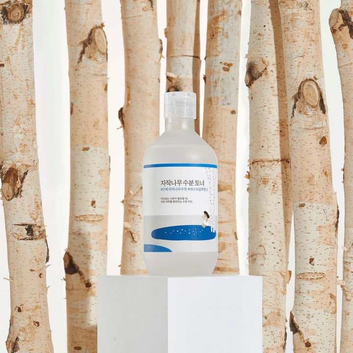 Round Lab Birch Juice Moisturizing Toner 300 ml kosteuttava kasvovesi vaaleassa pullossa koivunrunkojen keskellä.