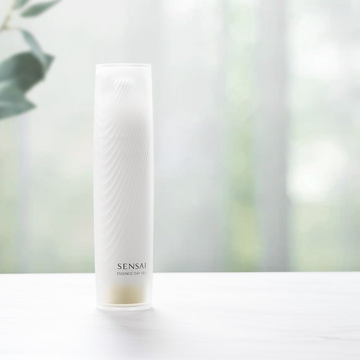 Sensai Essence Day Veil 40 ml suojaava päivävoide huurteisen valkoisessa aaltokuvioidussa pullossa.