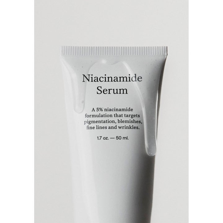 Jorgobé Niacinamide Serum 50 ml tasoittava kasvoseerumi valkoisessa tuubissa jonka päällä valuu kirkasta seerumia