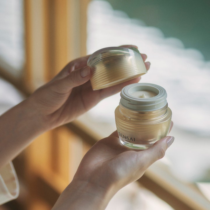 Sensai Ultimate The Cream 40 ml uudistava kasvovoide ylellisessä lasipurkissa käsien pitelemänä.