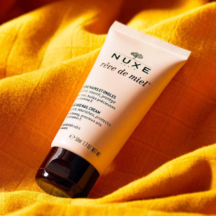 Nuxe Rêve de Miel Hand and Nail Cream 50 ml ravitseva käsivoide beigessä tuubissa keltaisella kankaalla