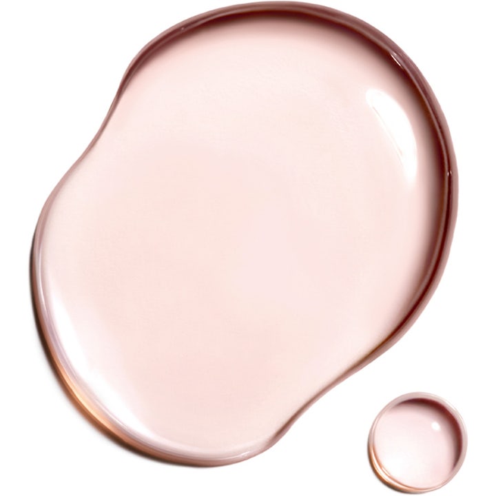 Clarins Super Restorative Treatment Essence 200 ml uudistava hoitoneste ja sen vaaleanpunainen maitomainen koostumus.