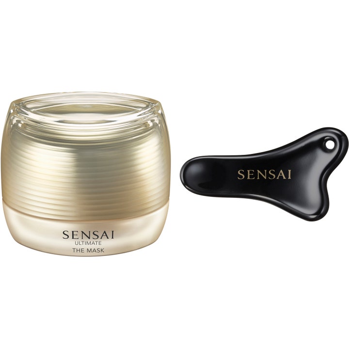 Sensai Ultimate The Mask 75 ml uudistava kasvonaamio ylellisessä kultaisessa purkissa mustalla hierontatyökalulla.