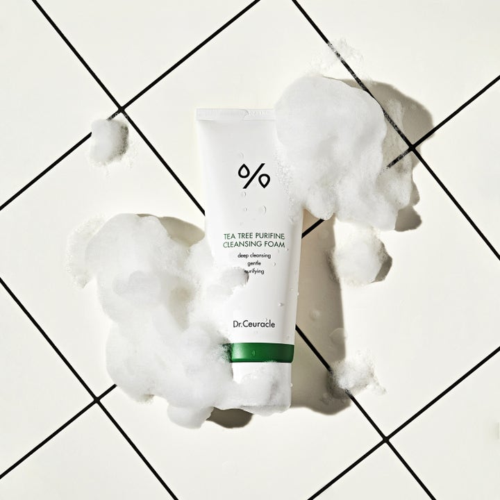 Dr. Ceuracle Tea Tree Purifine Cleansing Foam 150 ml puhdistusvaahto valkoisessa tuubissa ilmavan vaahdon ympäröimänä.