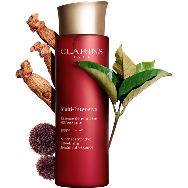 Clarins Super Restorative Treatment Essence 200 ml silottava hoitovesi punaisessa pullossa ginseng-juurten ympäröimänä