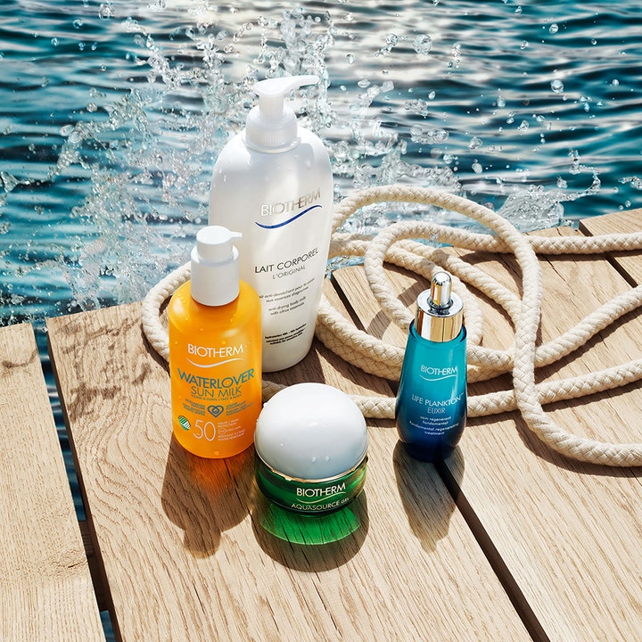 Biotherm Waterlover Sun Milk 200 ml aurinkovoide oranssissa pullossa aurinkoisella laiturilla veden äärellä