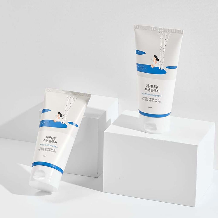 Round Lab Birch Juice Moisturizing Cleanser 150 ml kaksi valkoista tuubia valkoisilla korokkeilla.