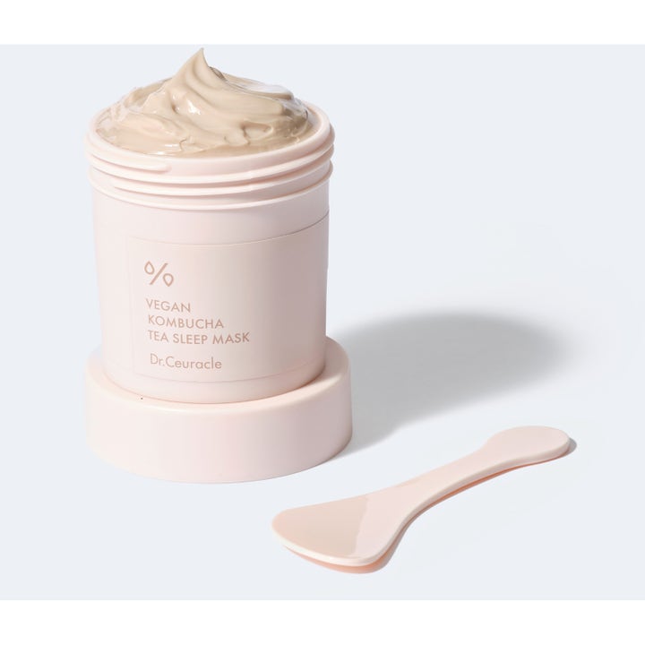 Dr. Ceuracle Vegan Kombucha Tea Sleep Mask 100 g kosteuttava yönaamio vaaleanpunaisessa purkissa spaattelilla.