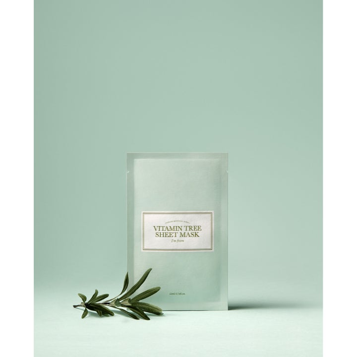 I'm from Vitamin Tree Sheet Mask 1 kpl kirkastava kangasnaamio vaaleanvihreä pussi vihreän oksan edessä.