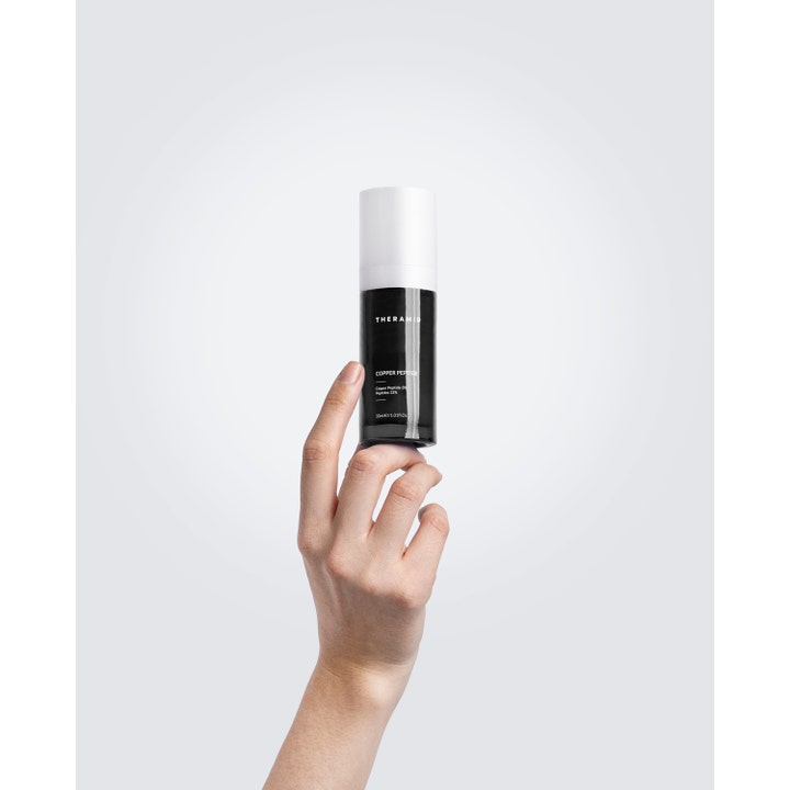 Niche Beauty Lab Theramid Copper Peptide 30 ml anti-aging seerumi käden pitelemässä mustassa pullossa