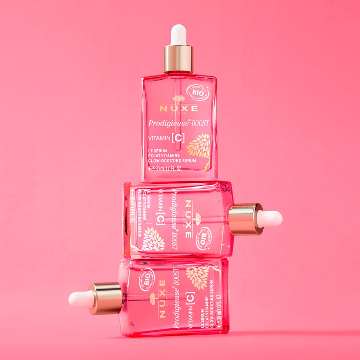 Nuxe Prodigieuse Boost Vitamin C Glow Boosting Serum 30 ml kolme kirkasta lasipulloa pinkillä taustalla