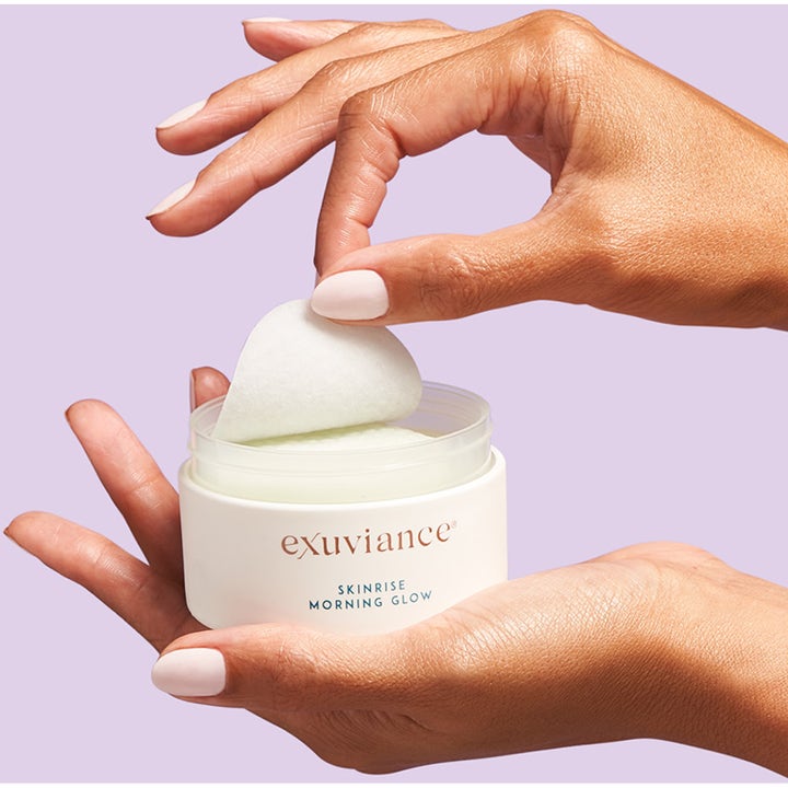 Exuviance SkinRise Morning Glow 36 kpl heleyttävä seerumi ja kosteat kasvotyynyt valkoisessa purkissa.