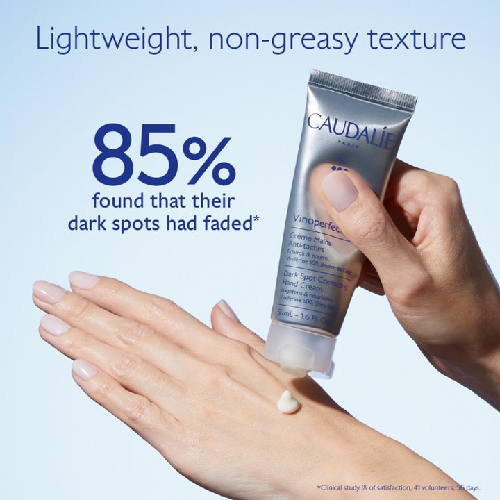Caudalie Vinoperfect Dark Spot Correcting Hand Cream 50 ml vaalentava käsivoide hopeisessa tuubissa iholle levitettynä.