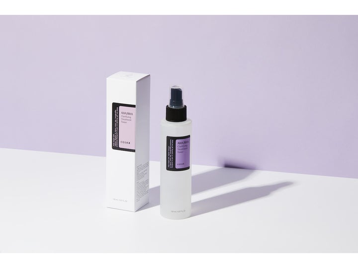 COSRX AHA/BHA Clarifying Treatment Toner 150 ml kirkastava kasvovesi valkoisessa pakkauksessa liilalla taustalla