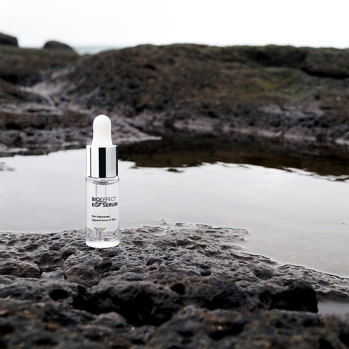 Bioeffect EGF Serum 15 ml kosteuttava kasvoseerumi lasipullossa tummilla vulkaanisilla kivillä veden luona.