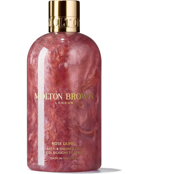 Molton Brown Rose Dunes 300 ml ylellinen suihkugeeli hohtavalla vaaleanpunaisella koostumuksella ja kultaisella korkilla