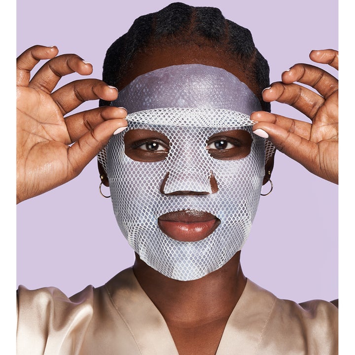 Exuviance Pick-Me-Up Plumping Mask 20 g täyteläistävä kangasnaamio mallin kasvoilla valkoisena verkkona.