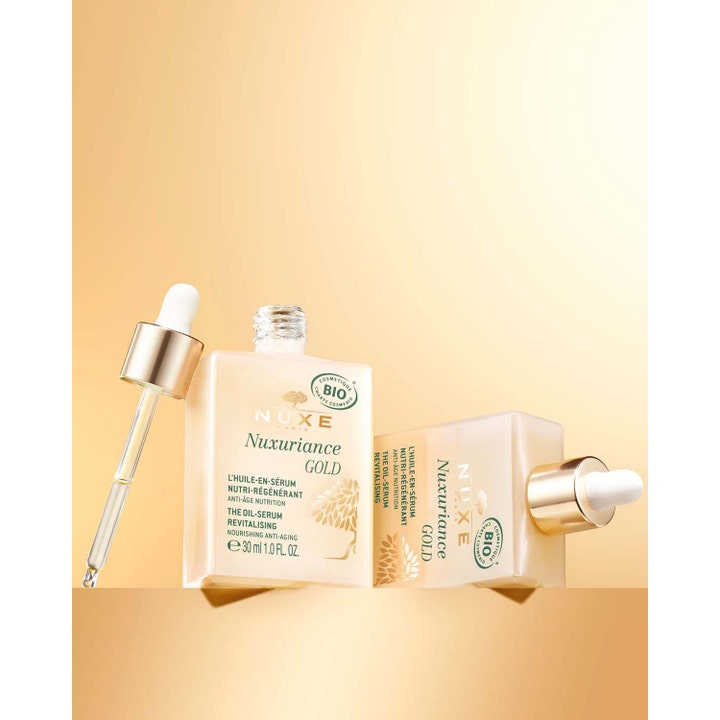 Nuxe Nuxuriance Gold 30 ml elvyttävä öljyseerumi lasipullossa ja pipetti kultaisella taustalla.