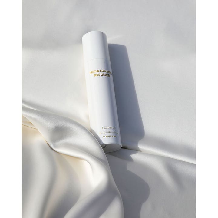 Lenoites Prestige Rebalancing Milk Cleanser 200 ml tasapainottava puhdistusmaito valkoisessa pullossa silkkikankaalla