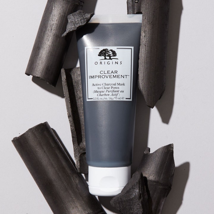 Origins Clear Improvement Active Charcoal Mask 75 ml puhdistava kasvonaamio harmaassa tuubissa hiilenpalojen seassa.