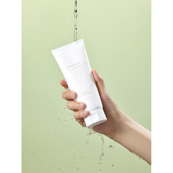 Mixsoon Centella Cleansing Foam 150 ml rauhoittava puhdistusvaahto valkoisessa tuubissa vesiroiskeiden keskellä.