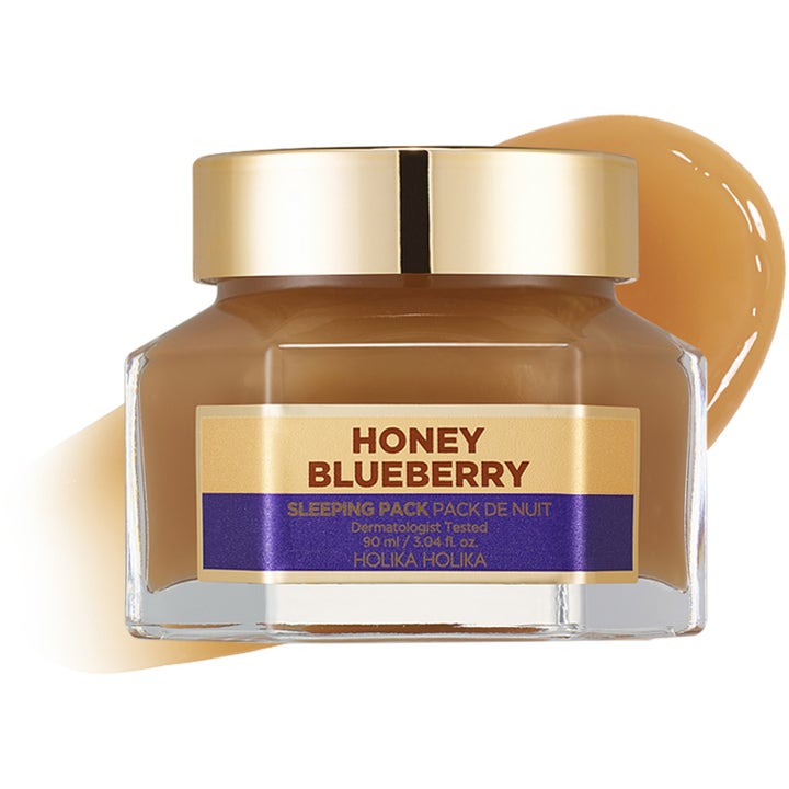 Holika Holika Honey Sleeping Pack Blueberry 90 ml kosteuttava yönaamio lasipurkissa kultakorkilla ja näyte koostumuksesta.