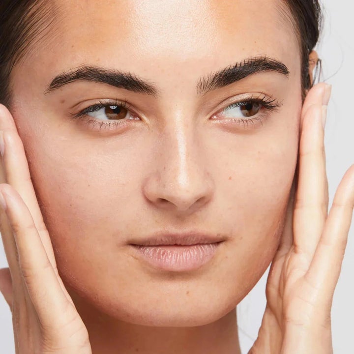 Dermalogica AGE smart Duo Skinperfect Primer SPF30 aurinkosuojalla silottaa ihoa naisen kasvoilla lähikuvassa.
