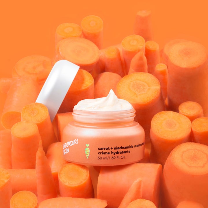 Saturday Skin Carrot + Niacinamide Moisturizing Cream 30 ml kirkastava kasvovoide oranssien porkkanoiden keskellä.