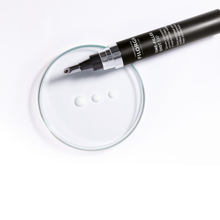 Filorga Time-Filler Shot 5XP 15 ml ilmejuonteita silottava seerumi ja valkoisia pisaroita lasimaljalla