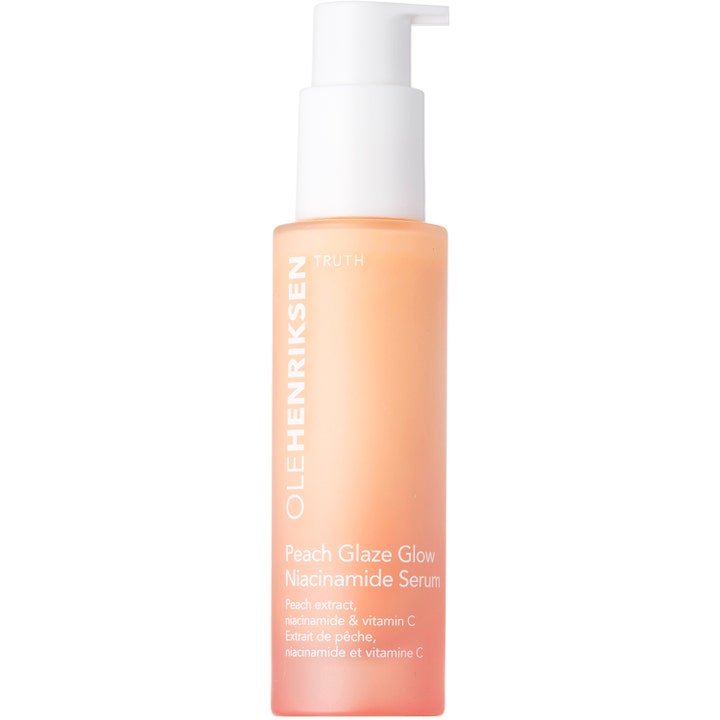 Olehenriksen Peach Glaze Glow Niacinamide Serum heleyttävä kasvoseerumi persikanvärisessä pullossa valkoisella pumpulla.