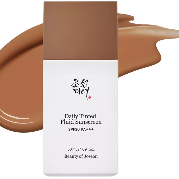 Beauty of Joseon Daily Tinted Fluid Sunscreen 50 ml sävytetty aurinkovoide valkoisessa pullossa ruskean voidevedon edessä