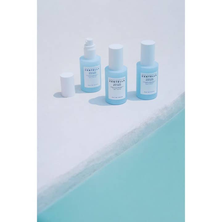 SKIN1004 Madagascar Centella Hyalu-Cica Blue Serum 30 ml kosteuttava seerumi vaaleansinisissä pumppupulloissa veden äärellä.