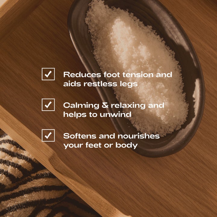 Bodyologist Calming Crystals Relaxing Foot &amp; Bath Salts 250 g rentouttava kylpysuola kiteinä pienessä tummassa kulhossa.
