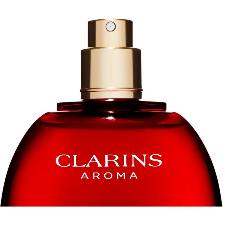 Clarins Eau Dynamisante 100 ml deodoranttisuihku punaisessa lasipullossa kultaisella suuttimella.