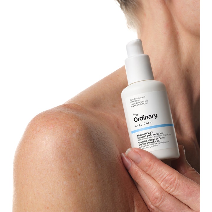 The Ordinary Niacinamide 5% Face & Body Emulsion 100 ml kirkastava voide valkoisessa pumppupullossa iholla.