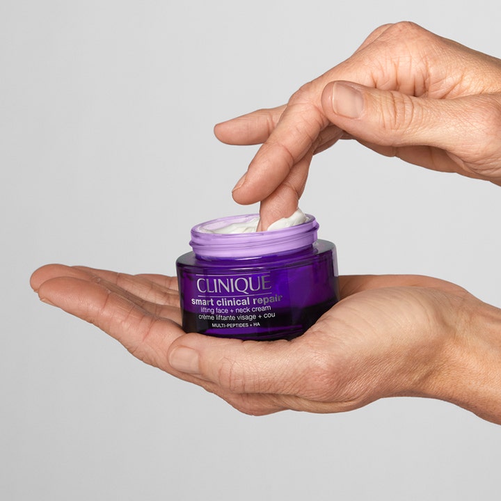 Clinique Smart Clinical Repair Lifting Face + Neck Cream 50 ml kohottava voide sormen ottaessa voidetta purppurasta purkista