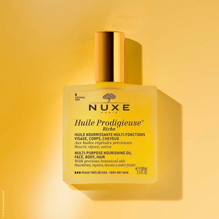 Nuxe Huile Prodigieuse Riche 100 ml ravitseva vartaloöljy huurteisessa lasipullossa keltaisella taustalla