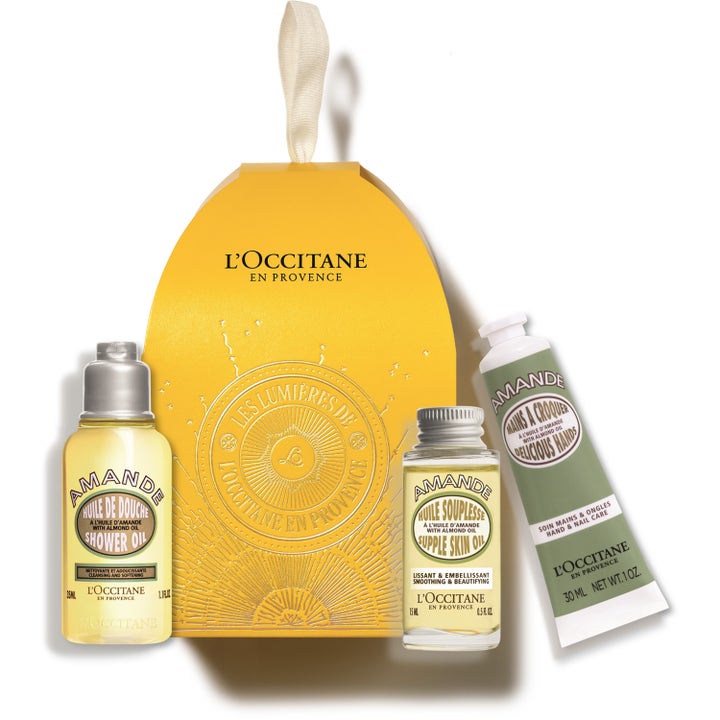 L'Occitane Amande -lahjasetti kosteuttava vartalonhoito keltaisessa kotelossa, jossa on kaksi öljyä ja käsivoide.
