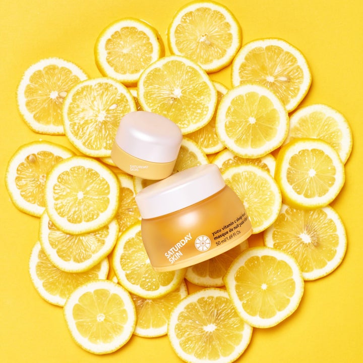 Saturday Skin Yuzu Vitamin C Sleep Mask 50 ml kirkastava yönaamio keltaisissa purkeissa tuoreiden sitruunaviipaleiden päällä.
