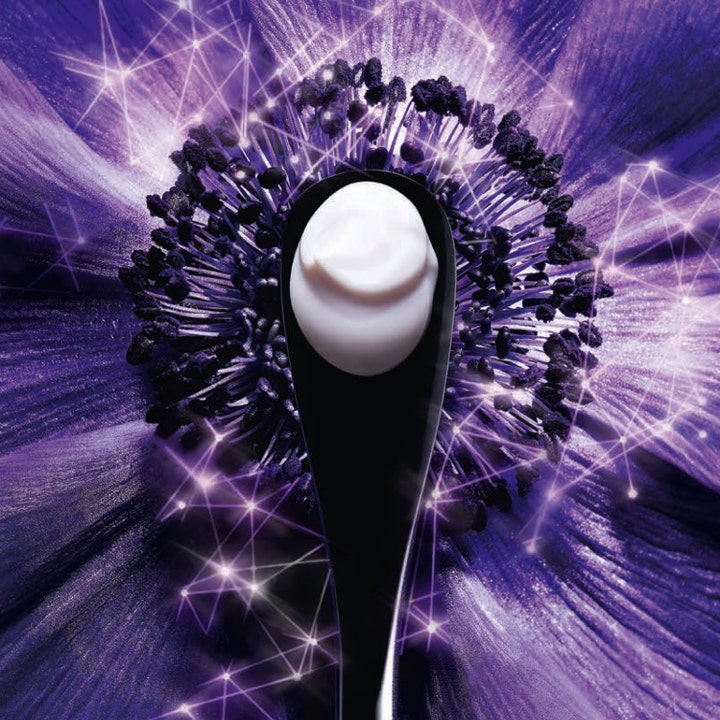 Lancôme Rénergie Multi-Lift Crème 50 ml päivävoide, jonka täyteläinen koostumus on mustalla spaattelilla lilan kukan päällä.