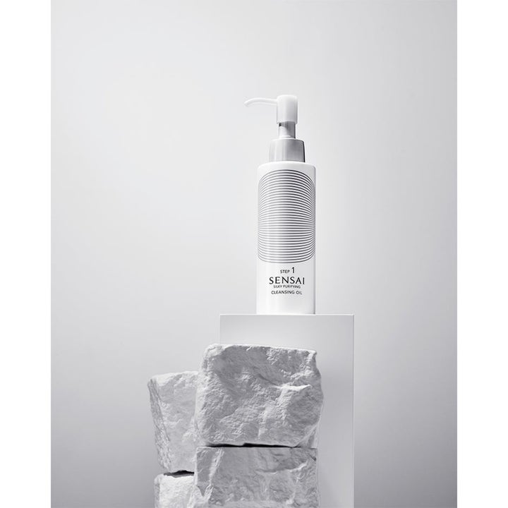 Sensai Silky Purifying Cleansing Oil 150 ml puhdistusöljy valkoisessa pumppupullossa vaalealla jalustalla.