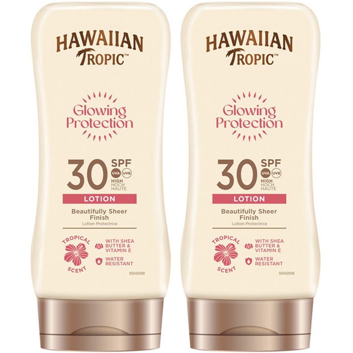 Hawaiian Tropic Glowing Protection SPF 30 aurinkovoide kahden pakkauksessa kaksi vaaleaa pulloa pronssisilla korkeilla.