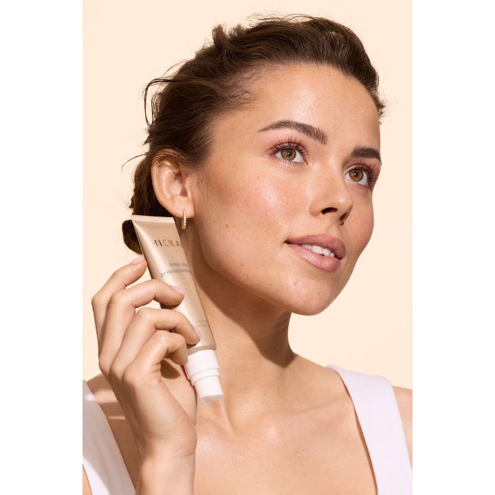 Hickap Hyaluronic Glow Set heleyttävä ihonhoitosetti antaa hehkua kultaisella seerumilla ja voiteella puulaatikon edessä.