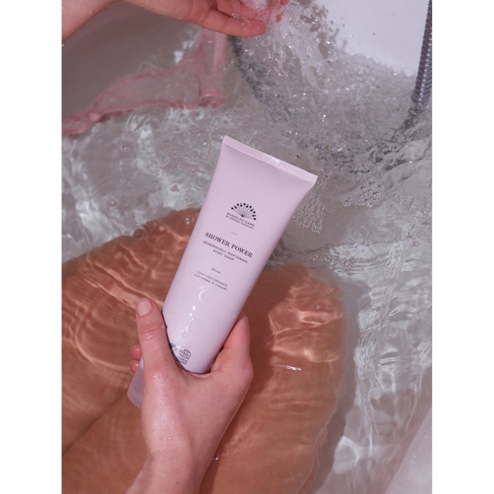 Rudolph Care Acai Shower Power 250 ml ihoa pehmentävä suihkugeeli vaaleanpunaisessa tuubissa veden alla.
