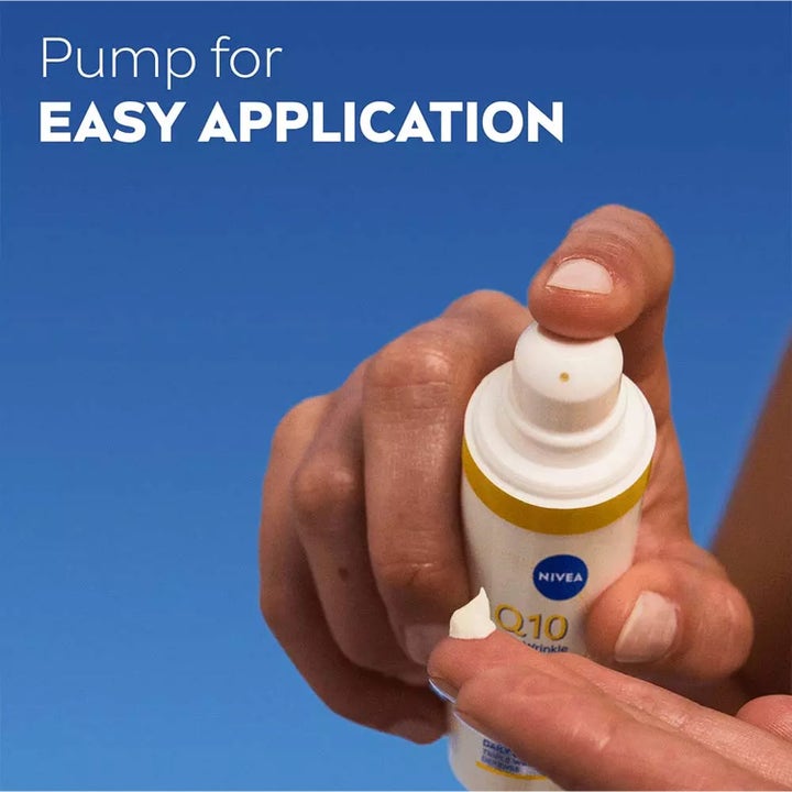 NIVEA Q10 Anti-Wrinkle Expert Daily UV Fluid 40 ml päivävoide SPF50, käsi annostelee valkoista voidetta pumpulla.