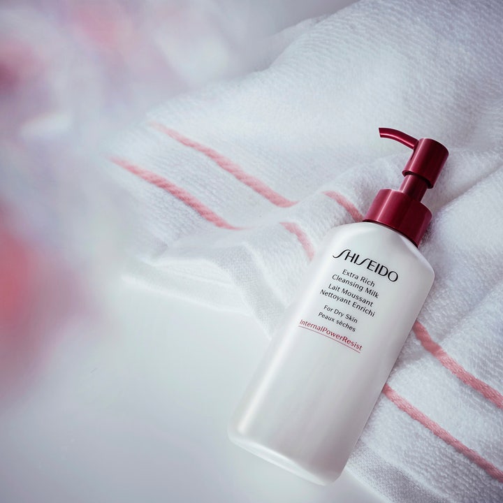 Shiseido Defend Extra Rich Cleansing Milk 125 ml puhdistusemulsio valkoisessa pumppupullossa pyyhkeen päällä.