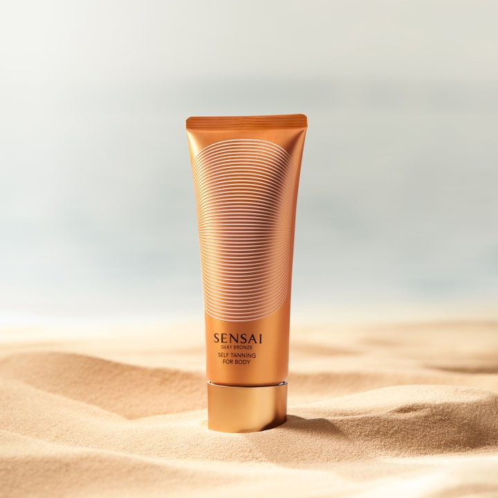 Sensai Silky Bronze Self Tanning For Body 150 ml itseruskettava vartalovoide hehkua tuovassa kuparituubissa hiekalla.