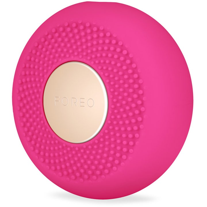 FOREO UFO mini 2 Fuchsia kasvohoitolaite kirkastaa ihoa pinkillä silikonipinnalla ja kultaisella yksityiskohdalla.
