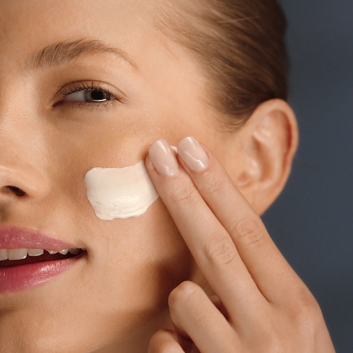 Estée Lauder Revitalizing Supreme + Night Cream 50 ml elvyttävä yövoide levitettynä kasvoille sormin.